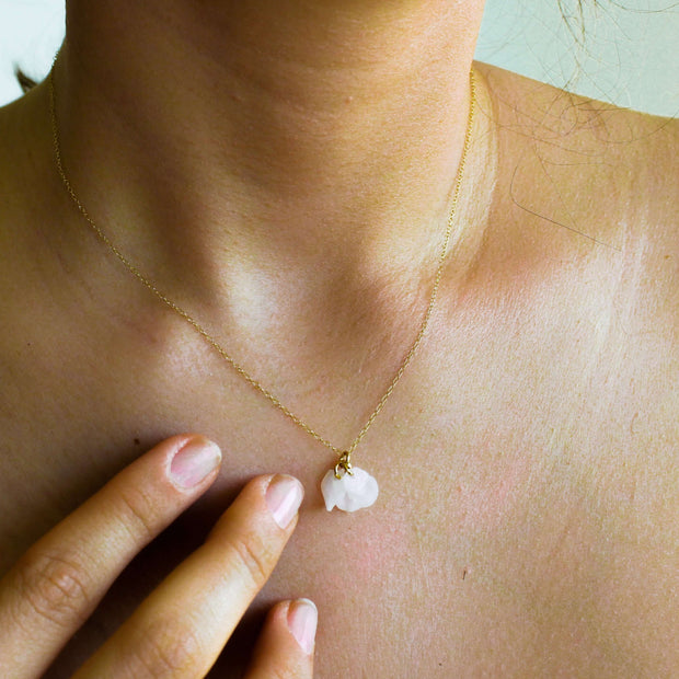 Eco-Chic Bloom: Sustainable 14k Gold Filled Petal Necklace worn on model, featuring delicate white petals and adjustable chain length.
