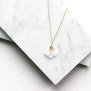 Catalina Necklace - 14k Gold Filled with white petal charms, displayed on a marble background. Sustainable and handmade using recycled metals.