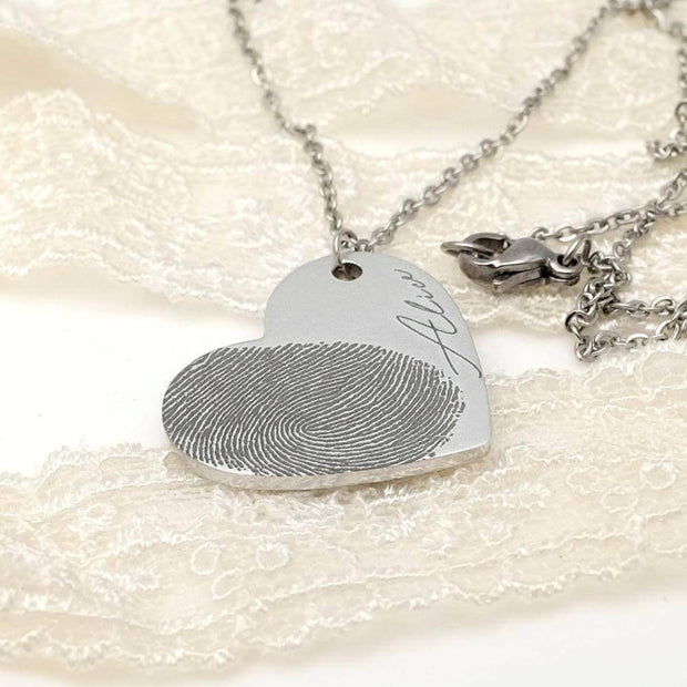 Silver Fingerprint Heart Necklace with 'Alice' engraving, custom memorial jewelry with fingerprint detail on lace background.