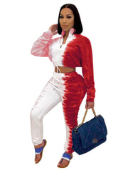 Woman wearing a red and white tie-dye outfit holding a blue handbag on a white background