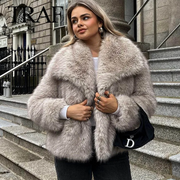 Woman wearing a fur coat standing on steps with a building in the background