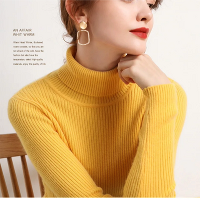 Person wearing a yellow turtleneck sweater with a blurred background