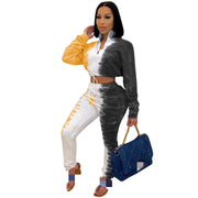 Woman wearing a colorful tie-dye outfit holding a blue handbag on a white background