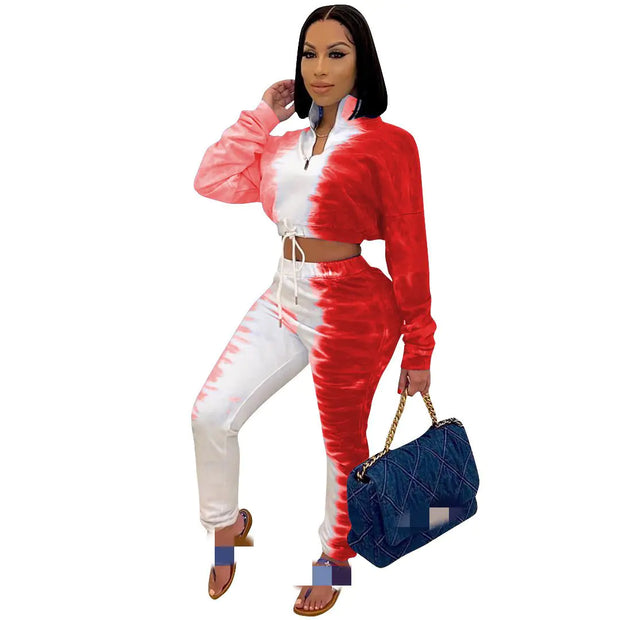 Woman wearing a red and white tie-dye outfit holding a blue handbag on a white background